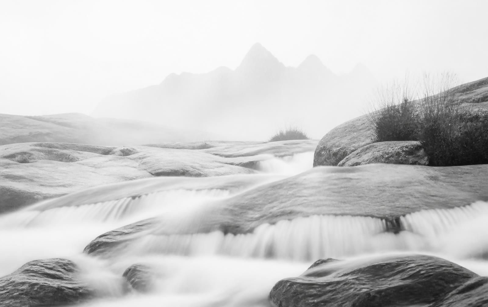 Mist over a mountain spring flowing across pale stone